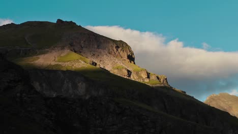 Sun-moves-on-grass-and-rocky-covered-hill