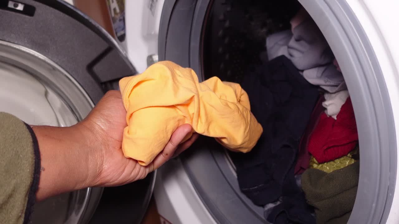 Putting clothes into the washing machine