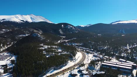 cars driving through snowy mountain peaks with coniferous forest in breckenridge colorado