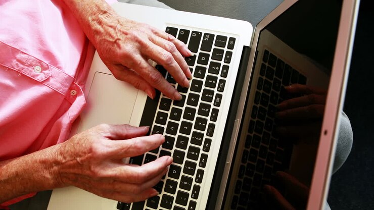 Over shoulder view of senior woman using laptop