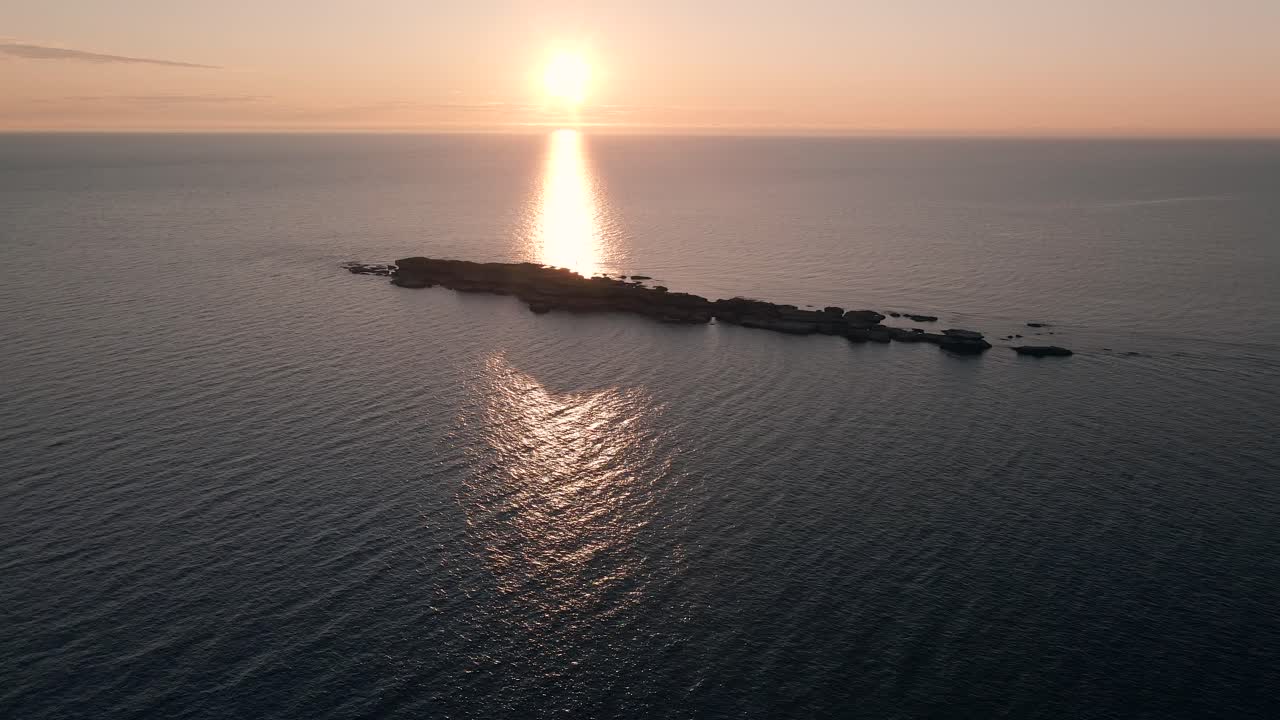 캐나다 퀘벡의 포인트 세인트 피에르 근처에 있는 평평한 섬과 함께 세인트 로렌스의 잔잔한 물에 반사되는 태양의 멋진 풍경