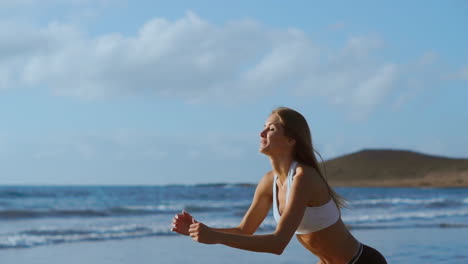 sportswoman wearing sportswear doing squats exercise outdoors. fitness female working out on the beach at sunset. athletic young woman is engaged in outdoor sports.