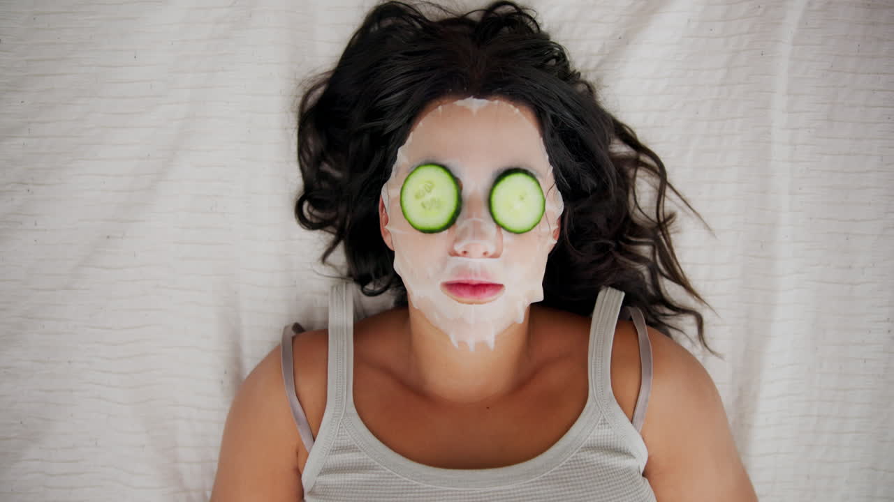 Woman with facial mask and cucumber slices