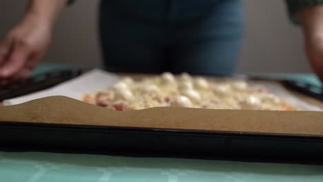 Woman-taking-home-made-pizza-fresh-from-the-oven