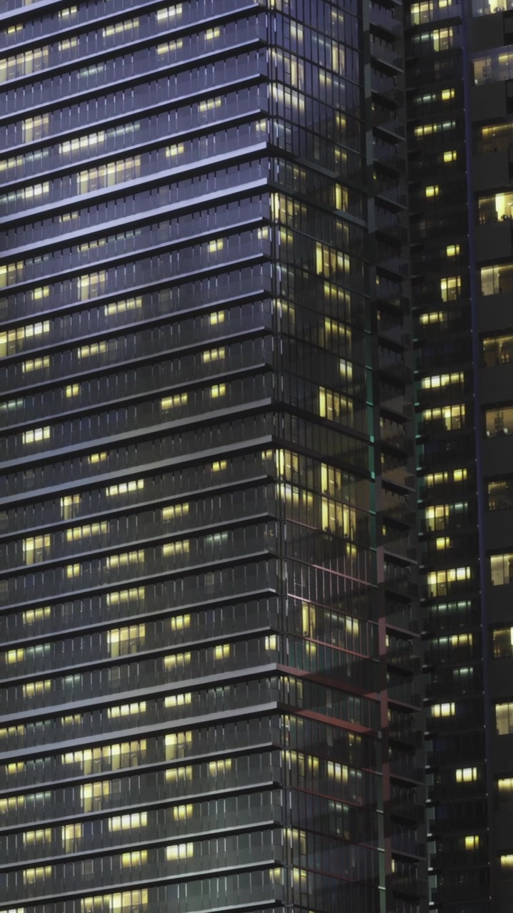 Modern office building illuminated at night with many lit windows
