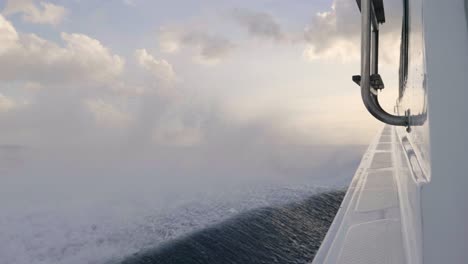 shot of a boat that travels at full speed, in the open sea between the waves crashing against the boat.