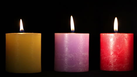 three candles on black