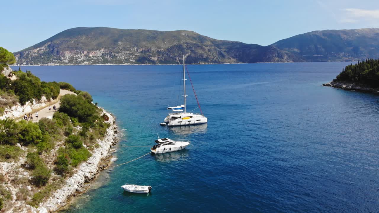 Navi di lusso ancorate sulla costa della spiaggia di Foki, vicino a Fiskardo, a Cefalonia, Grecia.