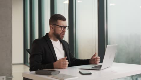 Un-Hombre-Enojado-Con-Ropa-De-Negocios-Golpea-Sus-Manos-Sobre-La-Mesa-Y-Se-Agarra-La-Cabeza-Mientras-Está-Sentado-En-La-Computadora