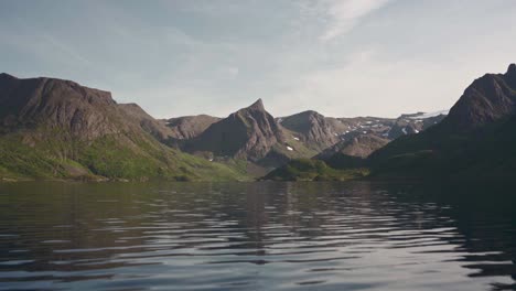 water rippling of lake with majestic mountain ranges in background during summer in norway