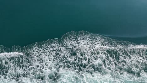 ocean waves as ship passes with beautiful blue water