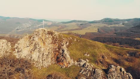 aerial view woman hiker reaching mountain peak and celebrate. goal achievement and healthy lifestyle. explore hiking trails georgia. kojori fortress