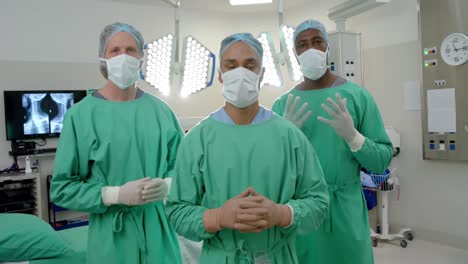 portrait of diverse male surgeons wearing surgical gowns in operating theatre, slow motion