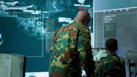 personal militar trabaja en un puesto de mando de una sala de monitoreo de alta tecnología