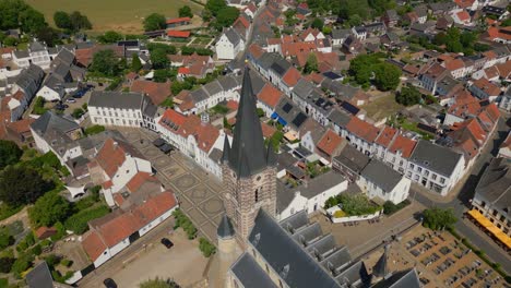 Drone-shot-over-the-idyllic-town-of-Thorn-in-the-municipality-of-Maasgouw,-Limburg-with-view-of-the-church-tower-with-historic-buildings-in-durch-architecture