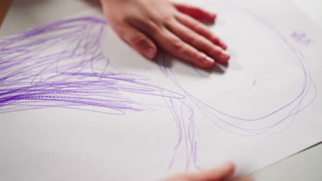 Little-girl-draws-character-with-purple-color-on-paper