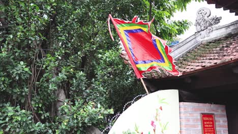 una bandera colorida ondea contra un telón de fondo de vegetación