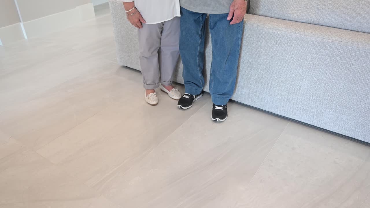 부부는 그들의 아름다운 거실에 서서 행복한 고객 서비스를 위해 엄지손가락을 표시합니다.