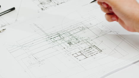 hand working on architectural blueprint