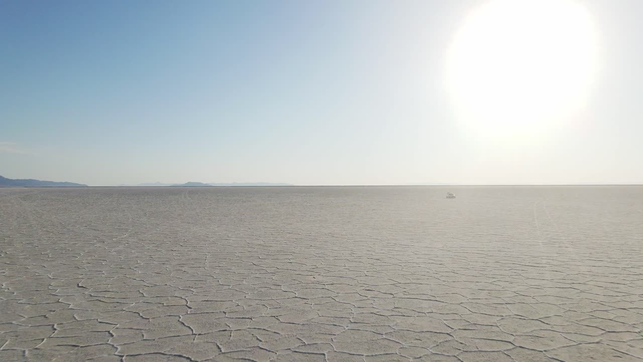 해와 지평선을 향해 날아다니는 소금 평야 위에서 조용한 드론이 촬영되었습니다.