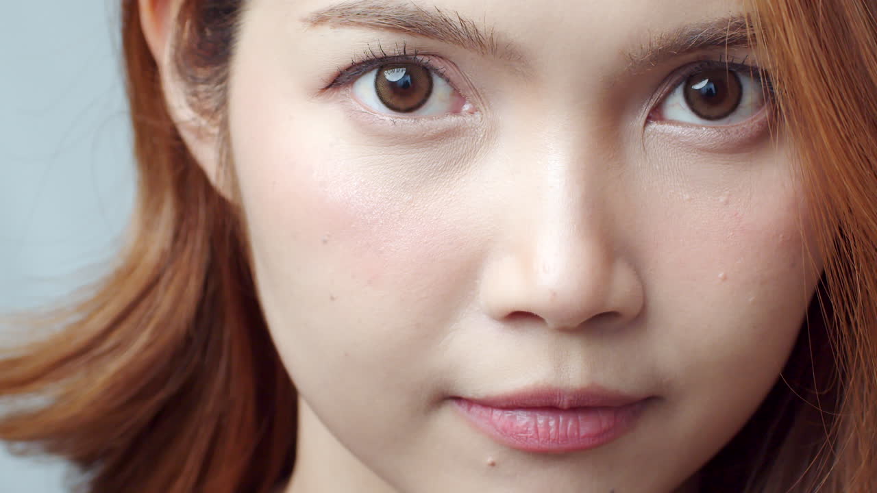 아파트에 주근깨가 있는 명랑하고 잘 생긴 젊은 빨간머리 여성은 카메라를 보고 진심으로 웃는다