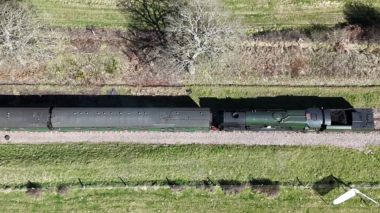 Stunning aerial footage of a romantic steam train gliding along scenic tracks, exuding vintage charm. Perfect for travel films, nostalgic storytelling and cinematic projects.