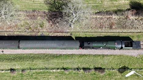 stunning aerial footage of a romantic steam train gliding along scenic tracks, exuding vintage charm. perfect for travel films, nostalgic storytelling and cinematic projects.