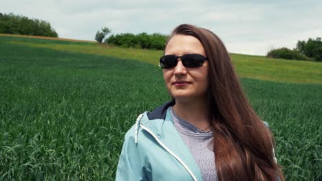 una mujer con gafas de sol cerca de un campo de avena