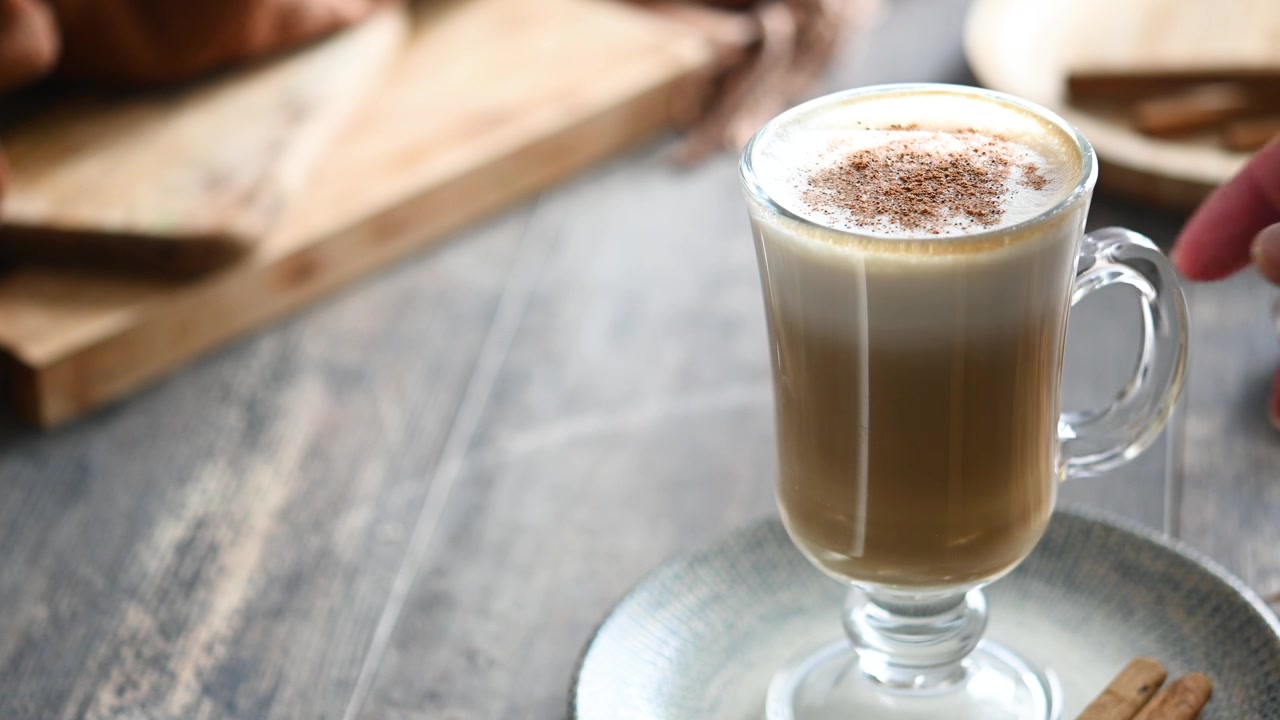Latte d'acero con cannella in tazza di vetro