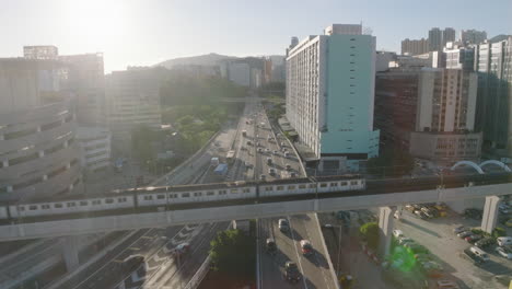 Backwards-shot-of-busy-highway-revealing-trains-passing-on-overpass