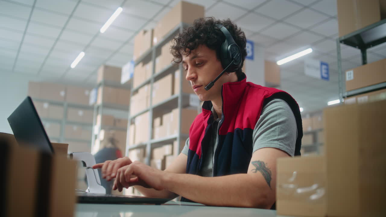 trabajador de almacén que utiliza portátil y auriculares