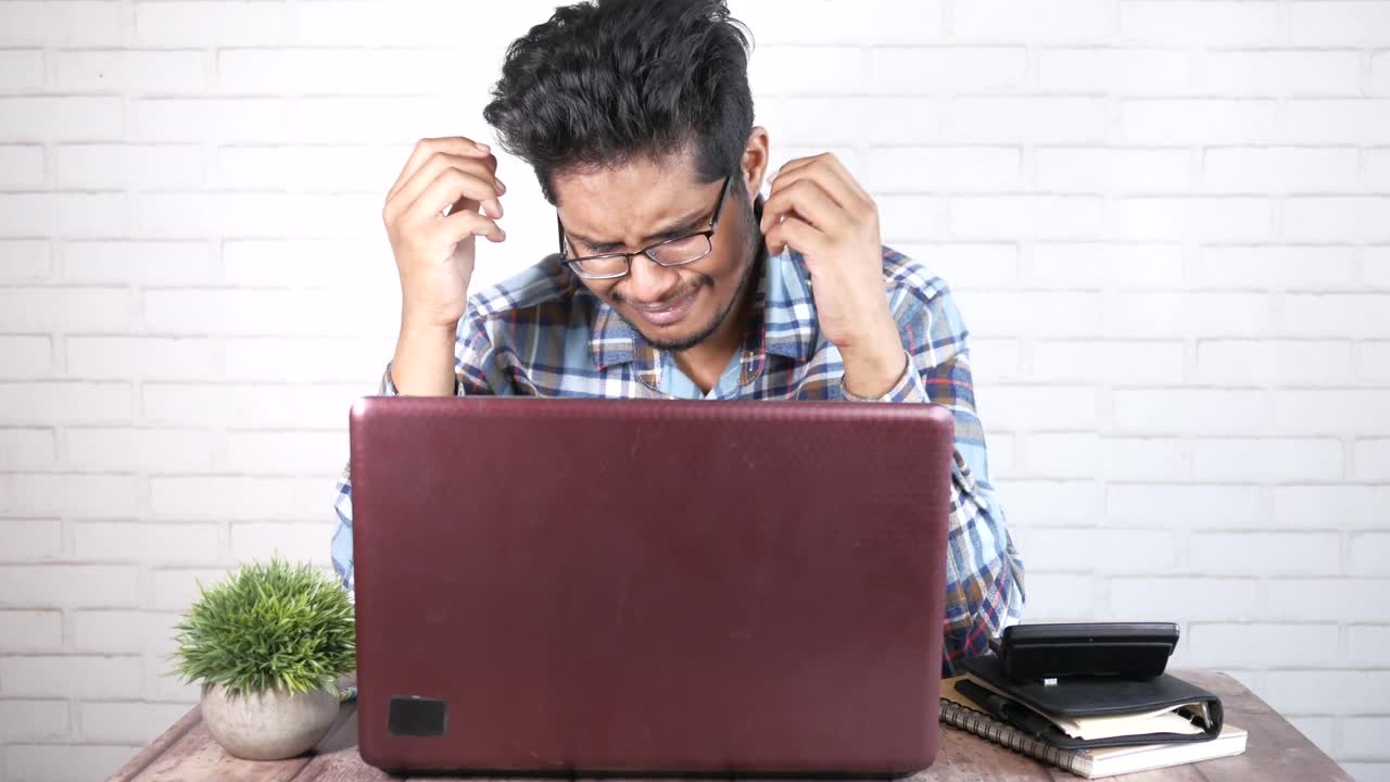 Stressed Man Working on Laptop