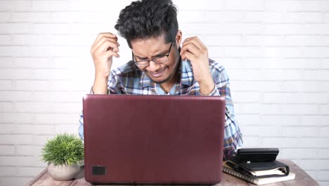 hombre estresado trabajando en una computadora portátil