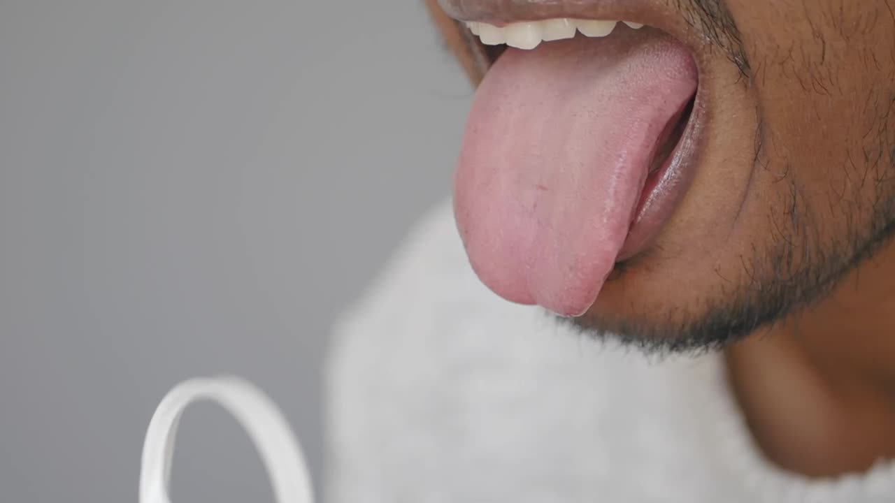 Using a tongue scraper for oral hygiene