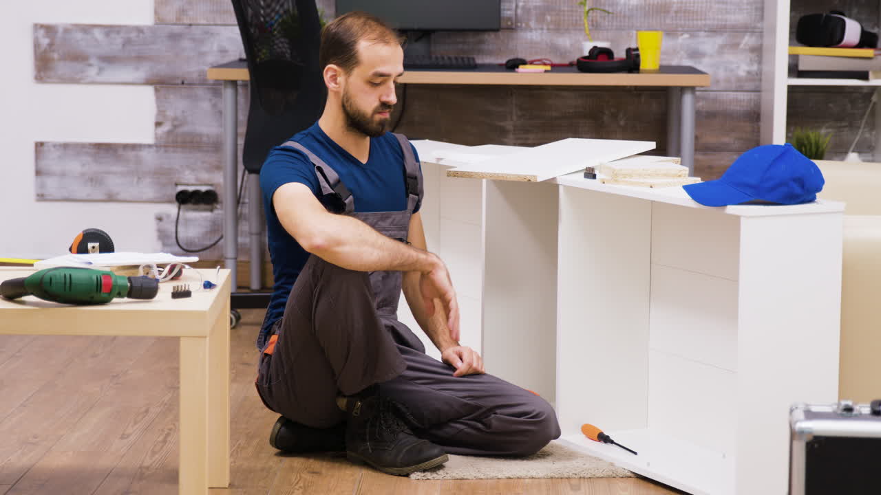 hombre montando muebles en la sala de estar