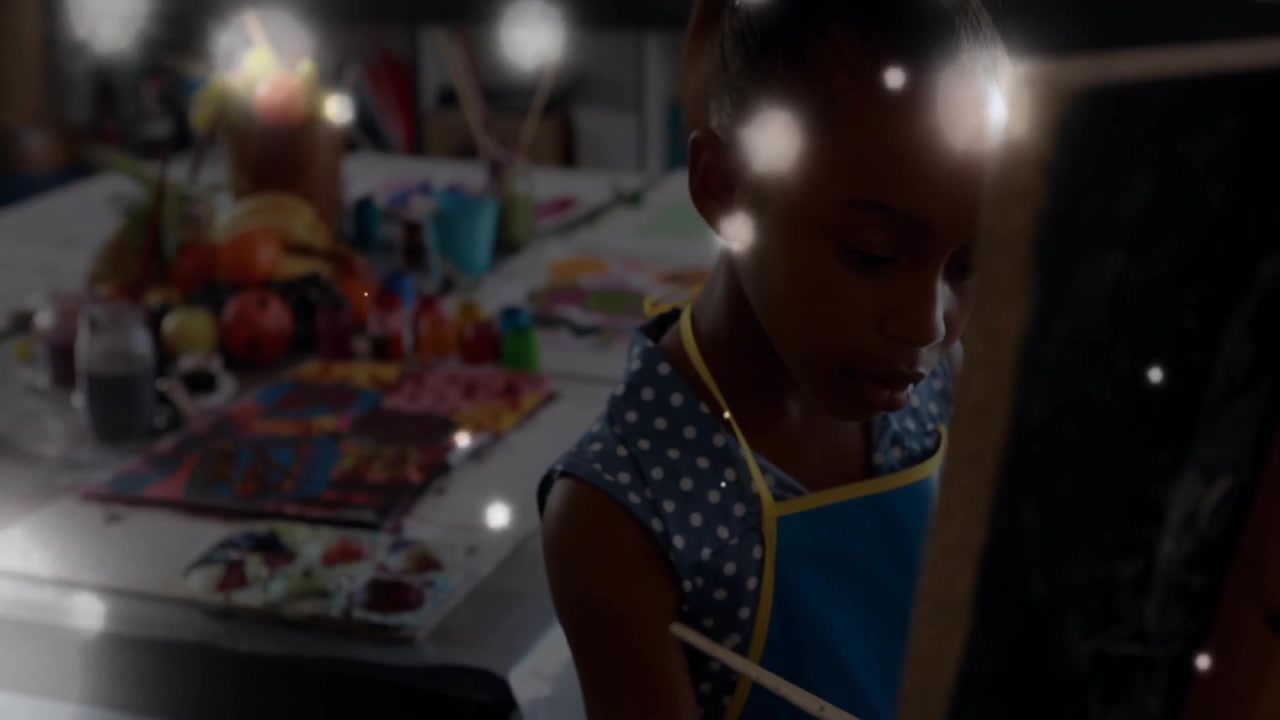 Student mixing paint and painting canvas creating art with animated light particles in classroom