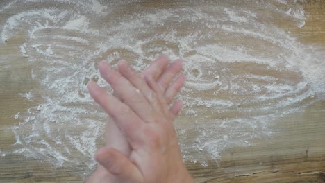 a baker, preparing to bake buns, sprinkles flour on the pastry board
