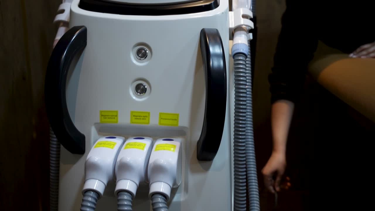 Le personnel de la clinique travaille à côté d'un appareil laser esthétique de haute technologie dans une salle de traitement moderne