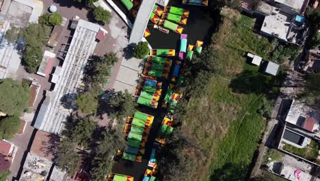 an aerial drone shot of colorful boats in xochimilco