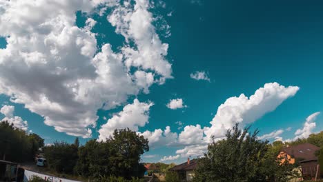 time lapse of clouds running over a turquoise sky above a suburb with houses