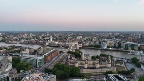 aerial approach from the north flying over the historic tower of london toward tower bridge, revealing a stunning contrast of medieval architecture and modern city skyline