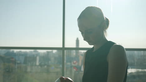 woman in boxing gloves by a window