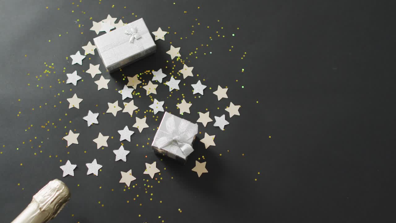 Presents and confetti with stars on black background at new year's eve