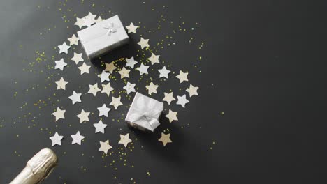 Presents-and-confetti-with-stars-on-black-background-at-new-year's-eve