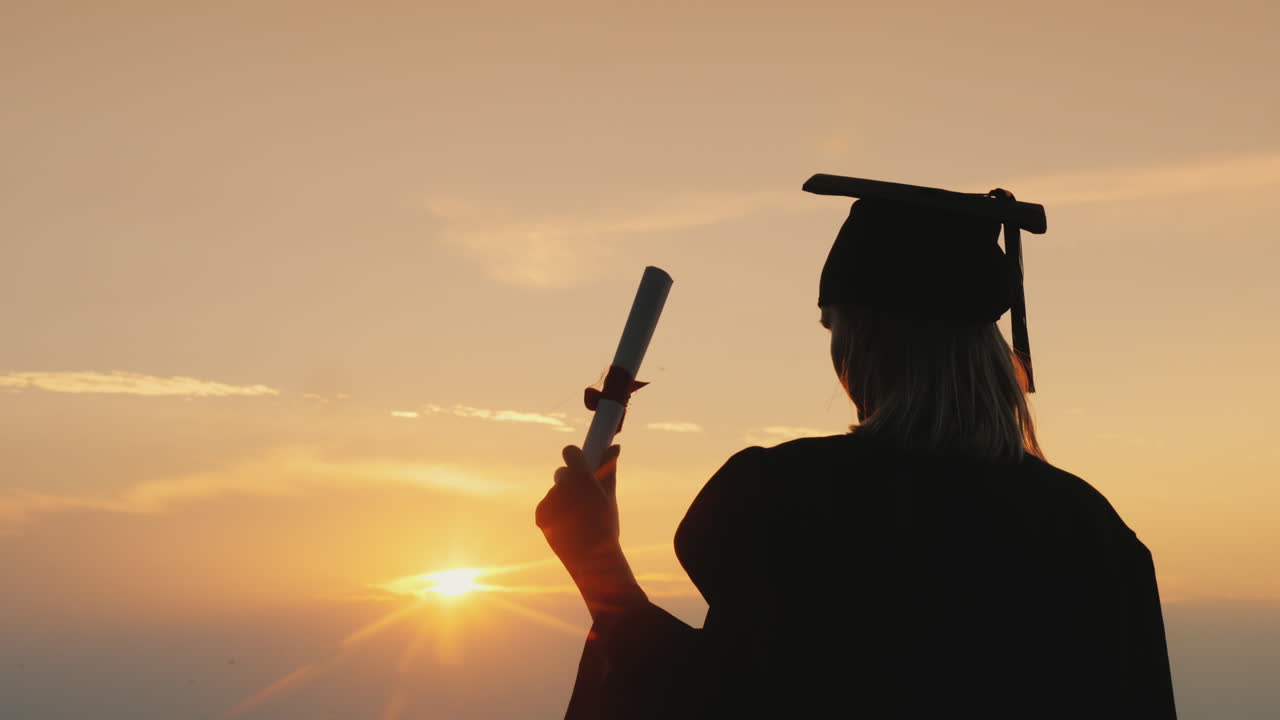 졸업장을 받은 졸업생은 바다 위의 일출을 바라본다 - 관점과 영감 개념