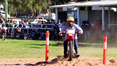 rider maneuvers motorcycle around barrels in arena