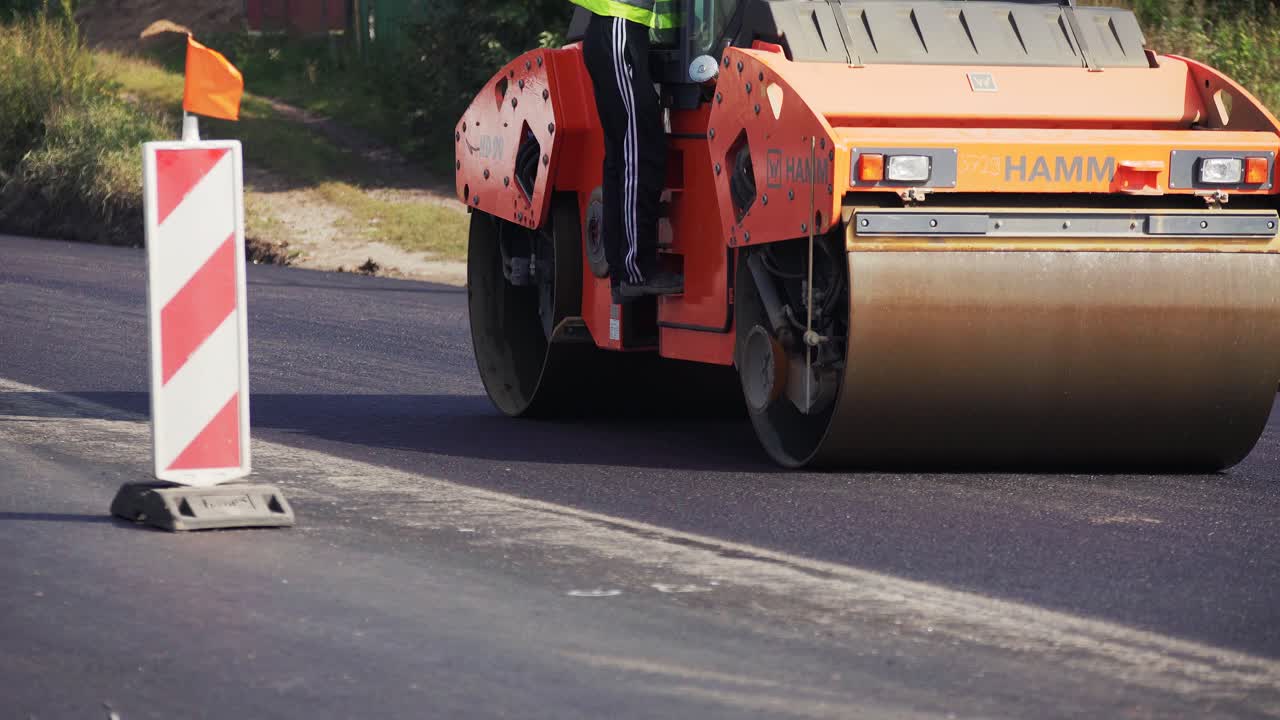 VINNYTSIA, UKRAINE - SEPTEMBER 10, 2018: Road roller laying fresh asphalt pavement