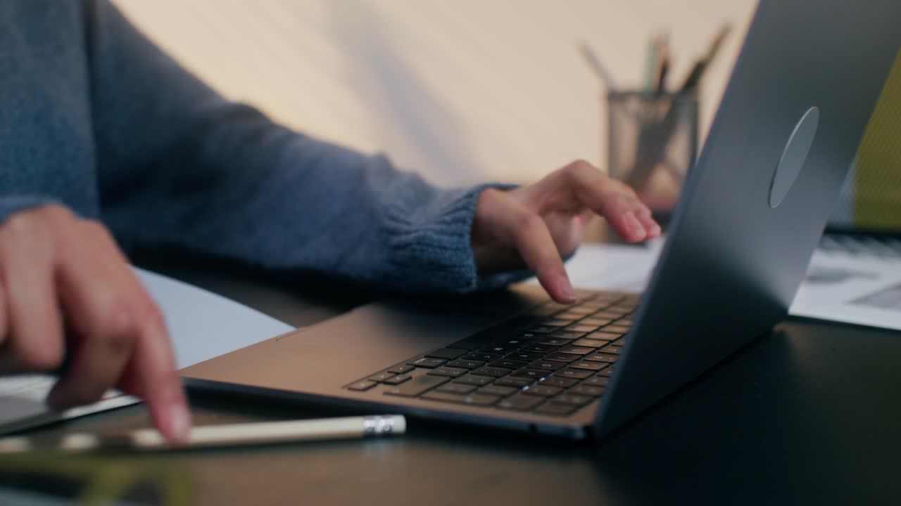 Student working on laptop and notebook