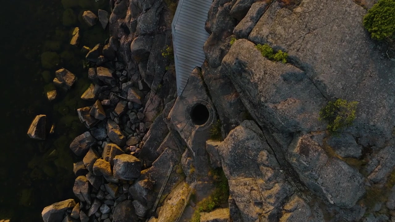 Ripresa con drone dall'alto che scende sopra una formazione geologica a marmitta dei giganti a Hanko.