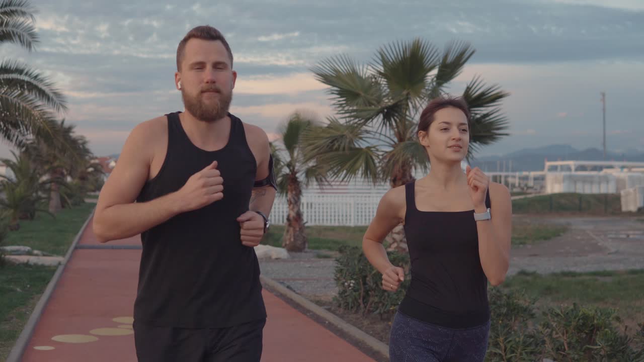 pareja corriendo por un camino costero
